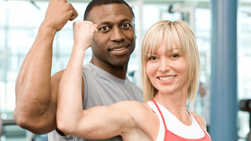 Picture of a lady and man standing showing their big biceps